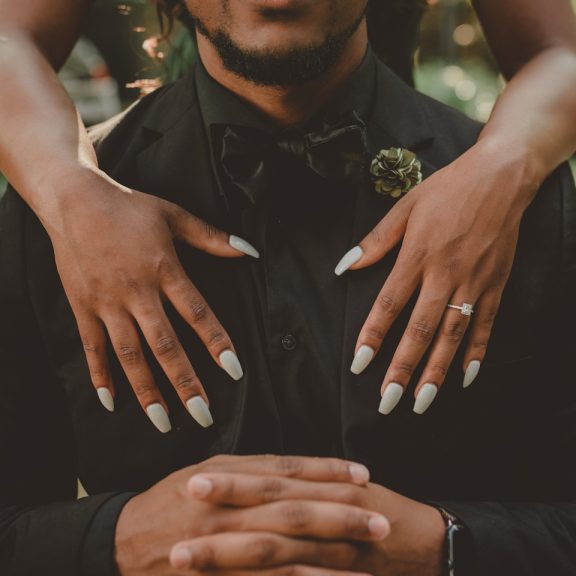 woman standing behind man in black tuxedo