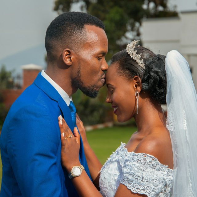 man kissing woman in forehead